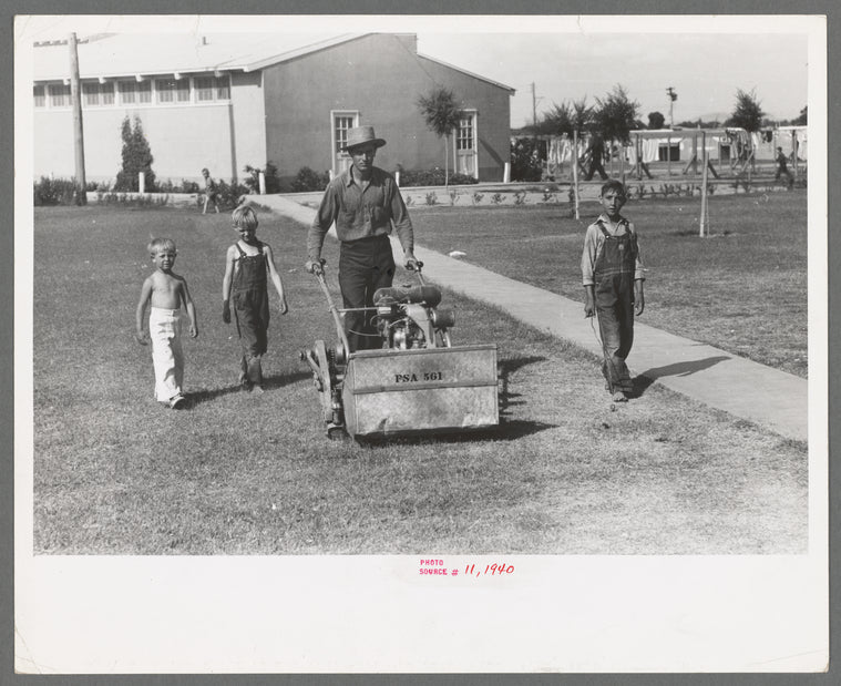 Worker mowing grass at the Agua Fria Migratory Labor Camp, Arizona